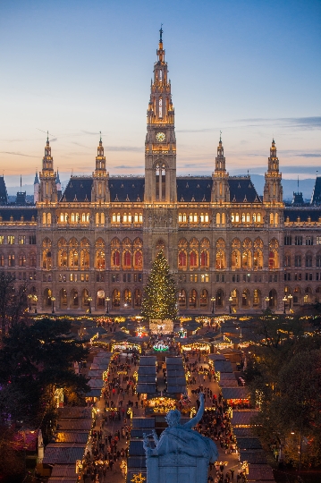 Ein Luftbild vom beleuchteten Wiener Rathaus mit dem geschmückten Weihnachtsbaum und Weihnachtsmarkt