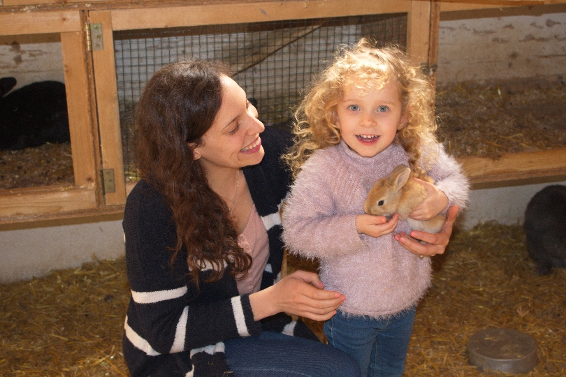 Ein Mädchen hält ein Kaninchen bei einer Stallführung am Landgut Cobenzl.
