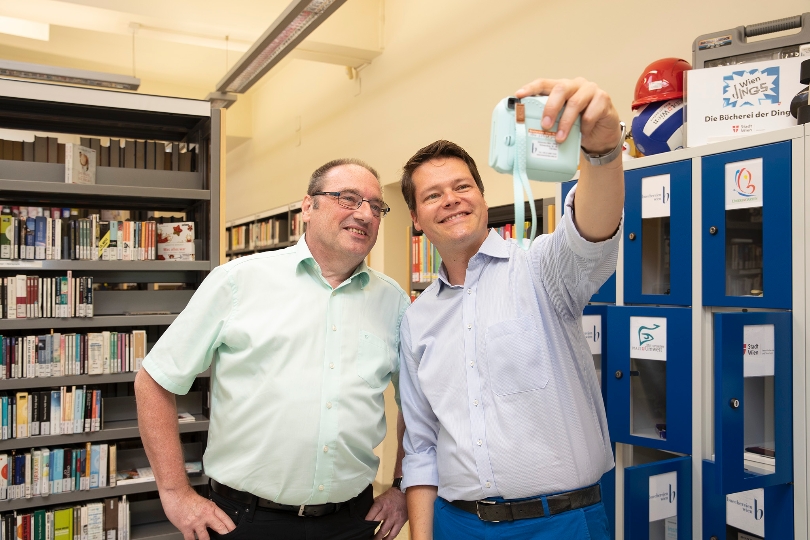 In der Bücherei-Zweigstelle am Schwendermarkt können Gegenstände wie etwa eine Sofortbildkamera ausgeborgt werden (Bezirksvorsteher Gerhard Zatlokal und Bildungsstadtrat Jürgen Czernohorszky, v.l.n.r.)