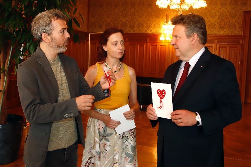 Die Künstler Maya Gelfman und Roie Avidan überreichten Bürgermeister Michael Ludwig im Rahmen der Aktion "Mind the Heart" ein Herz aus rotem Wollgarn.