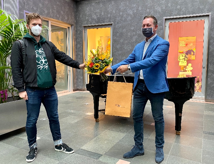 Haus der Musik-Direktor Simon Posch (re.) überreichte ein Goodie-bag und Blumen an den ersten Museumsbesucher nach der Wiederöffnung.