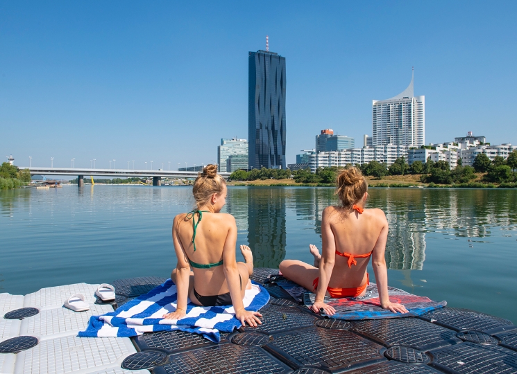 zwei Damen in Bikini sitzend auf Badesteg
