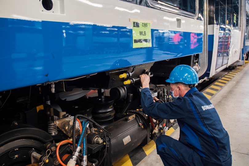 Ein technischer Arbeiter im Bombardier-Werk gibt der neuen Zug-Garnitur den Feinschliff.