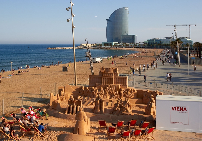 So wirbt Wien in Barcelona. Der WienTourismus bittet zum „Konzert“ eines überlebensgroßen Sand-Orchesters am Stadtstrand. 