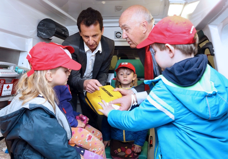 Stadtrat Christian Oxonitsch und der Präsident des Wiener Roten Kreuzes, Dr. Karl Skyba, mit Kindern beim Erste Hilfe-Training.