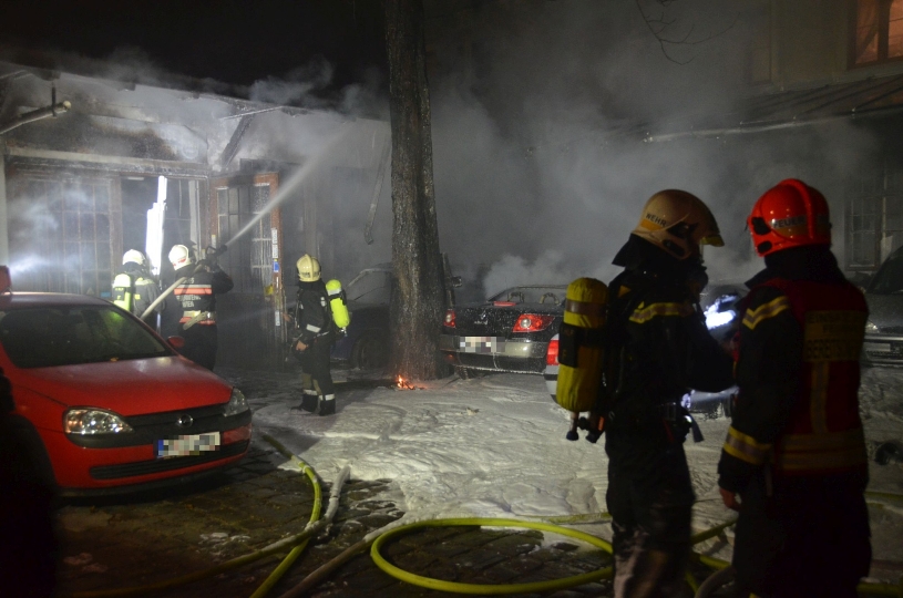 Feuerwehrleute beim Löschen des Brandes in einer Kfz-Werkstatt