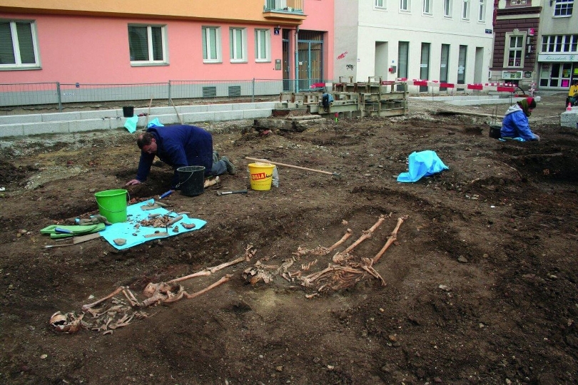 Ausgrabung des nördlichen Friedhofs mit vorne drei Gräbern ohne Sarg. 