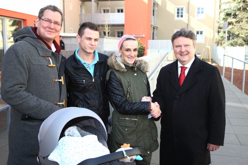 Bezirksvorsteher Georg Papai und Wohnbaustadtrat Michael Ludwig begrüßen Familie Nicole und Adi Halilovic, die mit ihrem zwei Wochen alten Söhnchen in die neue Wohnhausanlage einzieht.